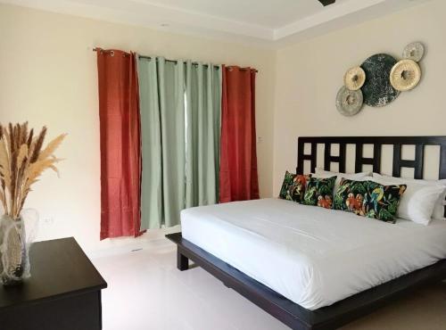 una camera da letto con un letto con tende rosse e verdi di Dreamscape Villa a Ocho Rios