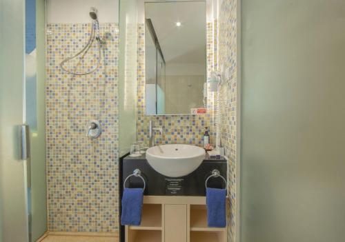 a bathroom with a sink and a mirror at Kuta Beach Hotel in Kuta