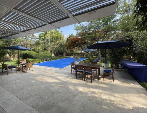 a patio with a table and chairs and umbrellas at Casa María de mi Corazón in Tepoztlán