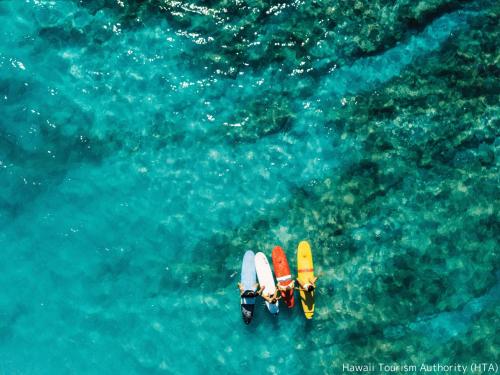 an overhead view of two people in the water with surfboards at First Cabin International Hawaii in Honolulu
