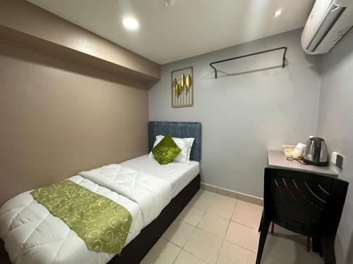 a small bedroom with a bed and a table at SS Grey Hotel Bukit Bintang in Kuala Lumpur