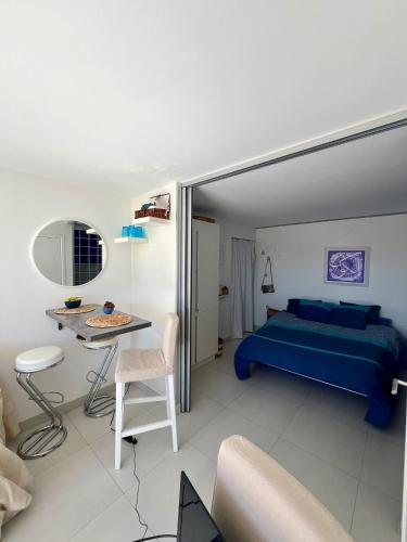 - une chambre avec un lit bleu et une table dans l'établissement Appartement moderne avec vue mer à Six-Fours-les-Plages, à Six-Fours-les-Plages