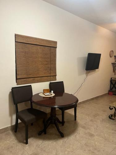 a dining room with a table and two chairs and a window at Apartamento Completo Cabo San Lucas in Cabo San Lucas