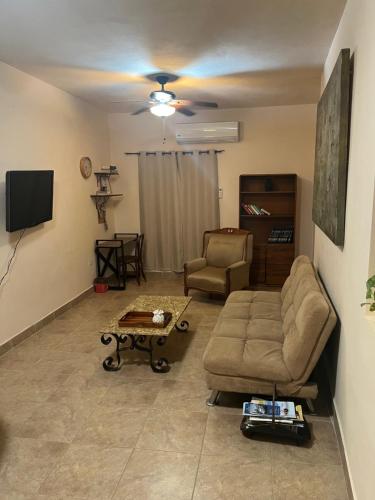a living room with a couch and a tv at Apartamento Completo Cabo San Lucas in Cabo San Lucas