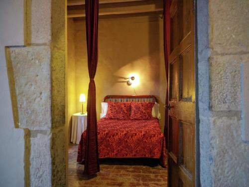 a bedroom with a bed with a red bedspread at Belvilla by OYO Can Guilella in Montmajor