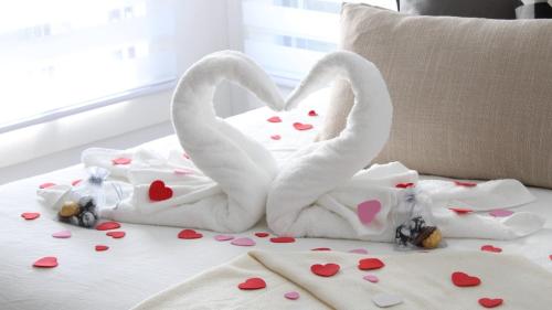 two swans made out of towels on a bed with hearts at Le Chalet Suisse in Mont-Blanc