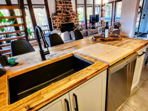 a kitchen with a wooden counter top with a sink at Le Chalet Suisse in Mont-Blanc