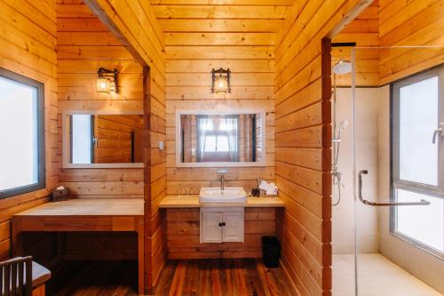 a wooden bathroom with a sink and a shower at Sutera at Mantanani Island Resort & Spa in Mantanani Island 