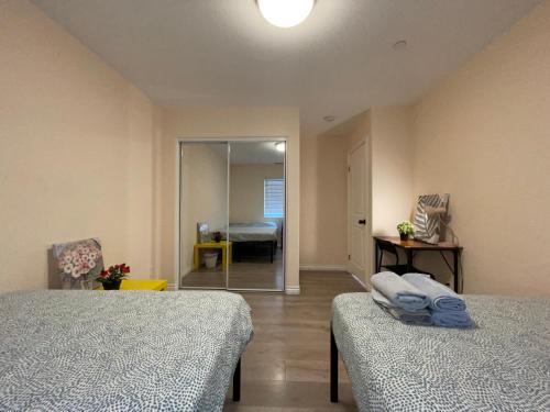 a room with two beds and a bedroom with a mirror at The Disney Hostel - Santa Ana in Santa Ana