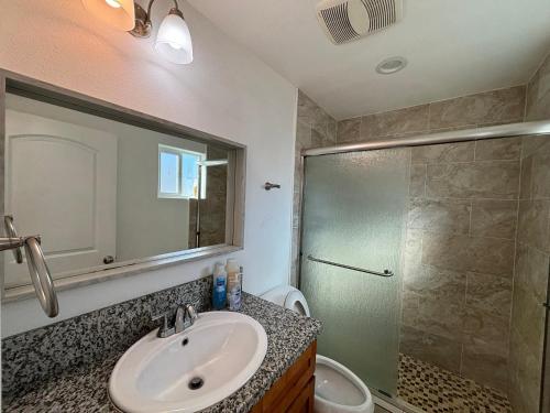 a bathroom with a sink and a shower at The Disney Hostel - Santa Ana in Santa Ana