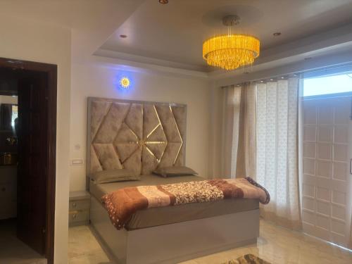 a bedroom with a bed and a chandelier at Anayah B and B in Shimla