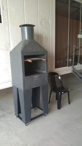 a stove in a room with a chair next to it at Condomínio Containers está localizado a 900m do centro de Morretes, local calmo e em meio a mata Atlântica in Morretes