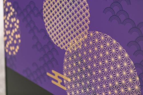 a close up of a purple and gold tie at Hotel TEMARI Matsumoto in Matsumoto