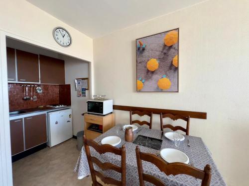 une cuisine avec une table et une horloge au mur dans l'établissement Studio rénové avec parking et animaux admis à Saint-Jean-de-Monts - FR-1-323-430, à Saint-Jean-de-Monts