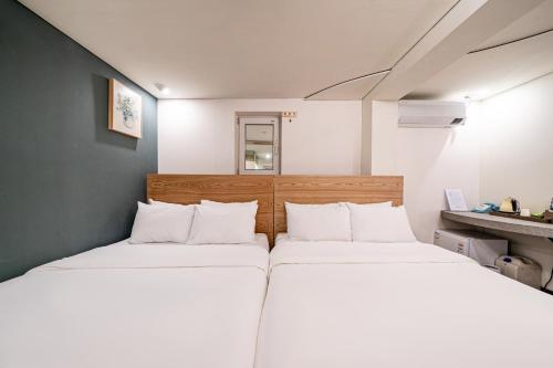 two beds in a small room with white walls at SimpleStay Hotel in Jongno in Seoul