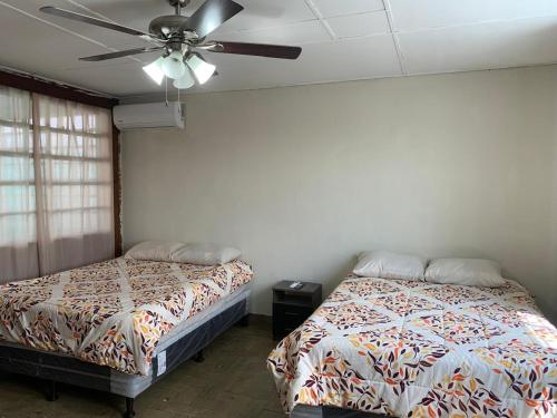 a bedroom with two beds and a ceiling fan at Hostal primaveras nest centro santa ana in Santa Ana