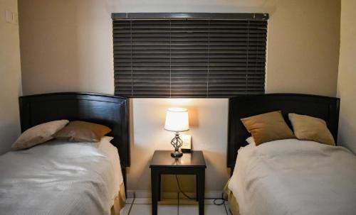 a bedroom with two beds and a table with a lamp at Tiara Sands 302 in Mazatlán
