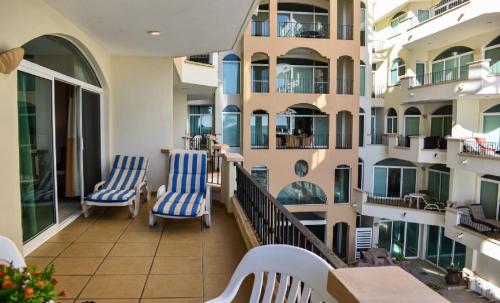 a balcony of a building with blue and white chairs at Tiara Sands 302 in Mazatlán