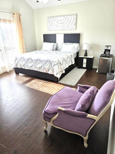 a bedroom with a king sized bed and a chair at Host Lux in Rowlett