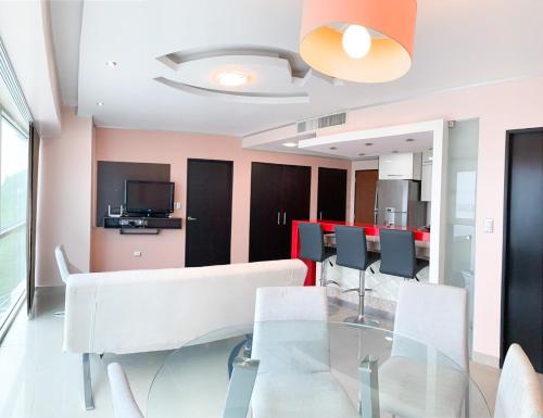 a dining room with a glass table and chairs at Departamento con Piscina, Jacuzzi y GYM in Guayaquil