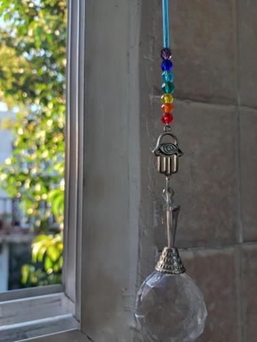 a glass object hanging from a wall next to a mirror at Hostel en Almirante Brown in Villa Martín Arín