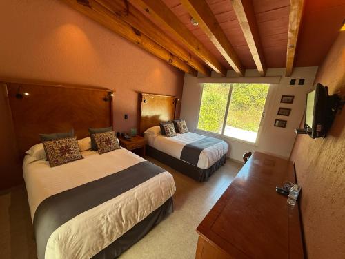 Ένα ή περισσότερα κρεβάτια σε δωμάτιο στο ANUIES Valle de Bravo HOTEL y CONVENCIONES