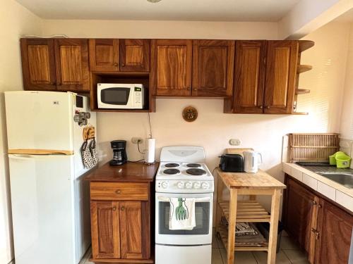 a kitchen with a white stove and a white refrigerator at Pineapple Condo At Villa Riviera in Coco