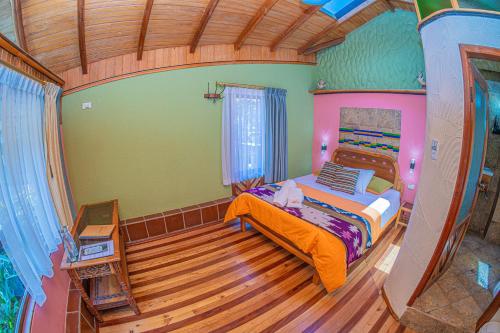 a bedroom with a bed and a wooden floor at Hotel y Spa Isla de Baños in Baños