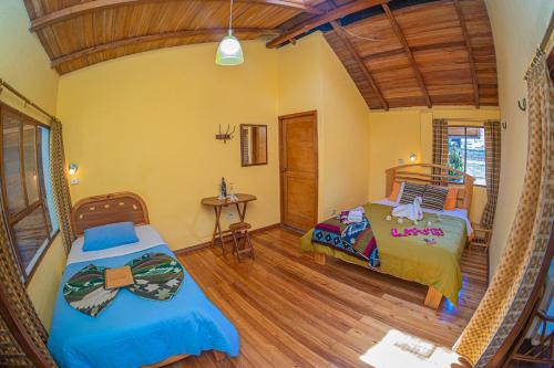 a bedroom with two beds and a wooden floor at Hotel y Spa Isla de Baños in Baños