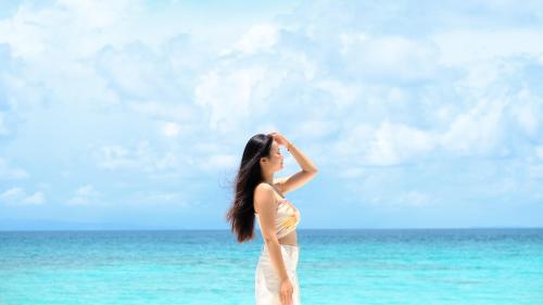 a woman standing on the beach looking at the ocean at Sutera at Mantanani Island Resort & Spa in Mantanani Island 