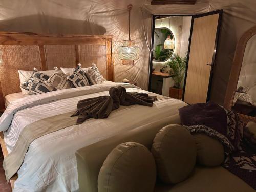 a bedroom with a large bed with a robe on it at Beachfront Luxury Dome Villas - Gamat Bay Resort in Nusa Penida