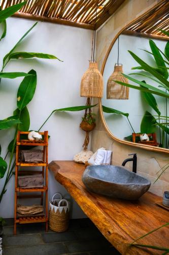 a bathroom with a stone sink and a mirror at Beachfront Luxury Dome Villas - Gamat Bay Resort in Nusa Penida