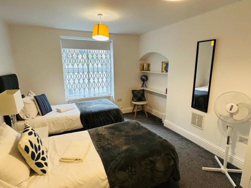 a hotel room with two beds and a window at Harrington Apartments in Central London in London