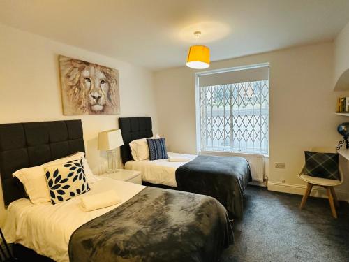 a hotel room with two beds and a window at Harrington Apartments in Central London in London