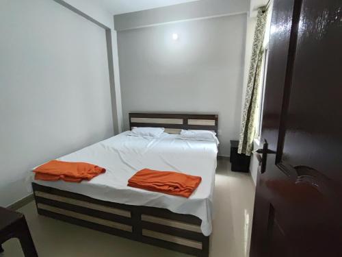 a bedroom with a bed with two orange towels on it at RAGHAV SADAN Luxury Apartment in Prayagraj