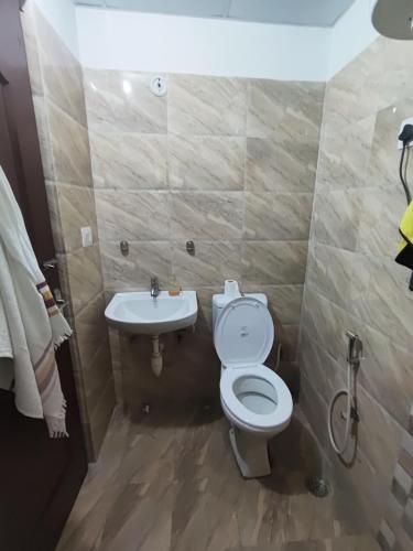 a bathroom with a toilet and a sink at RAGHAV SADAN Luxury Apartment in Prayagraj