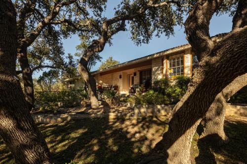 a house with trees in front of it at Blair House Inn and Spa in Wimberley