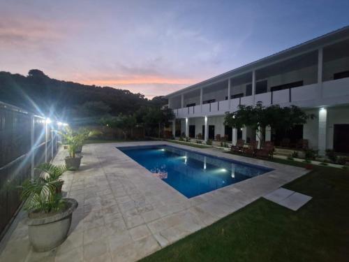 a swimming pool in front of a building at night at Satu Hati Hotel in Ekas