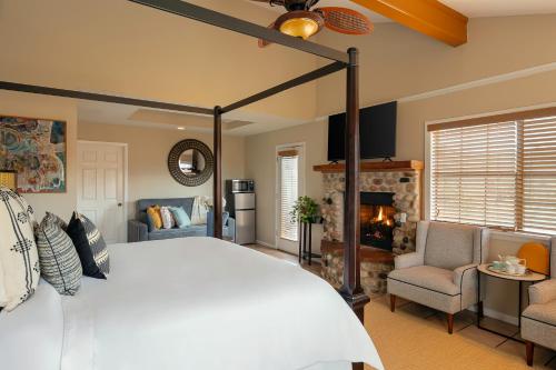 a bedroom with a white bed and a fireplace at Blair House Inn and Spa in Wimberley