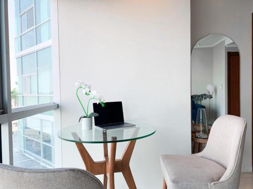 a glass table with a laptop on it in a room at Departamento con Piscina, Jacuzzi y GYM in Guayaquil