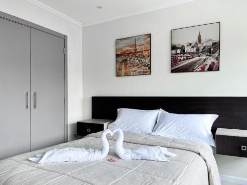 a bedroom with a bed with a swan on it at Departamento con Piscina, Jacuzzi y GYM in Guayaquil