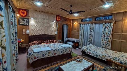 a bedroom with two beds and a couch at Highland Queen Houseboat in Srinagar