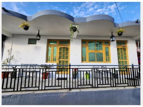 a house with yellow doors and a black fence at The Founder's Tribe in Bīr