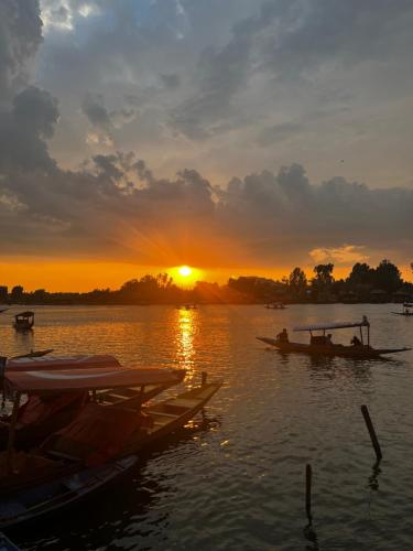 a group of boats on the water at sunset at Highland Queen Houseboat in Srinagar