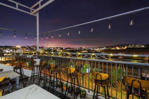 a balcony with chairs and tables and lights at Teen Hillside Đà Lạt- View Nhà Lồng lãng mạn in Da Lat