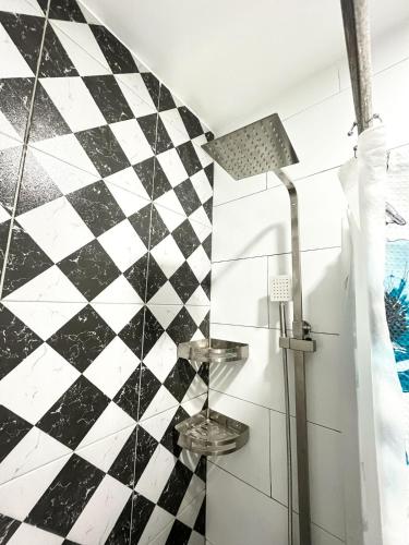 a bathroom with a black and white checkered wall at Up To 13 PAX near Clark Speedway & Aqua Planet in Angeles
