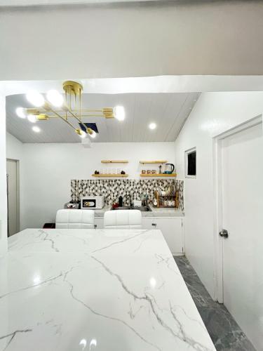 a kitchen with white walls and a marble floor at Up To 13 PAX near Clark Speedway & Aqua Planet in Angeles
