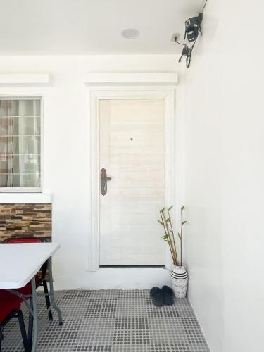 a white door in a room with a table and a plant at Up To 13 PAX near Clark Speedway & Aqua Planet in Angeles
