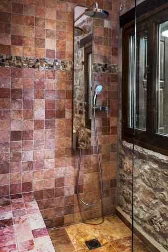 a shower in a bathroom with brown tiles at Elafos Spa Hotel in Elliniko