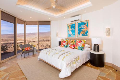 a bedroom with a bed and a large window at Hale 'O Ka La in Hapuna Beach